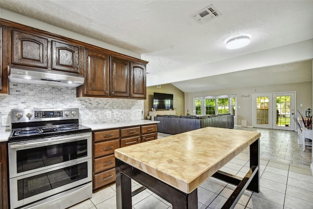 kitchen with double oven range, french doors, lofted ceiling with beams, a textured ceiling, and dark brown cabinets