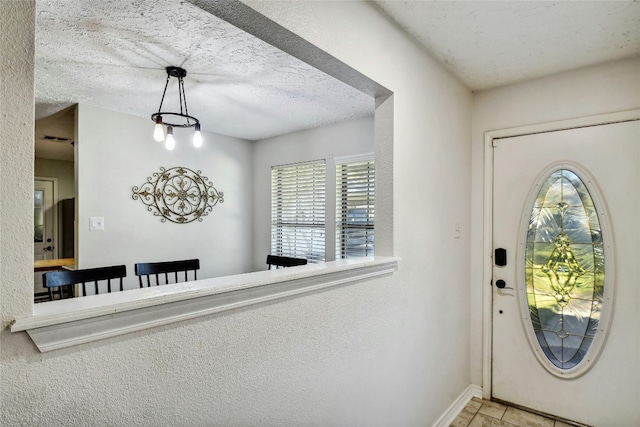 entryway featuring a textured ceiling and a notable chandelier