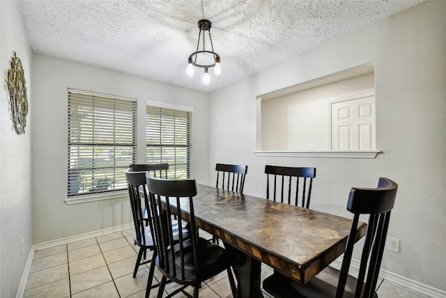 tiled dining area featuring a textured ceiling