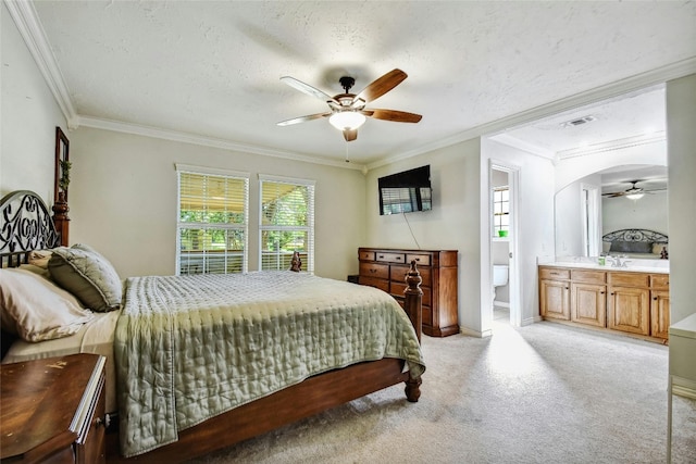 bedroom with multiple windows, light carpet, ensuite bathroom, and ceiling fan