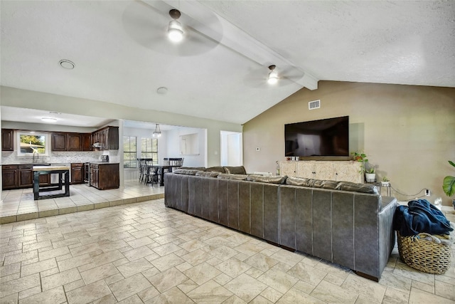 living room featuring ceiling fan and lofted ceiling with beams