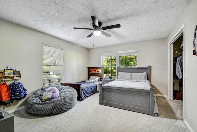 carpeted bedroom featuring ceiling fan and a textured ceiling