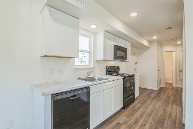 kitchen featuring dark hardwood / wood-style flooring, sink, white cabinetry, and black appliances