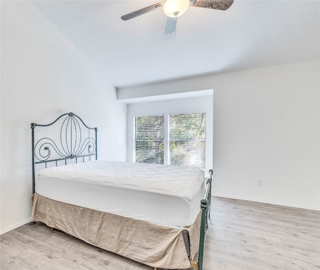 bedroom featuring ceiling fan, lofted ceiling, and light hardwood / wood-style flooring