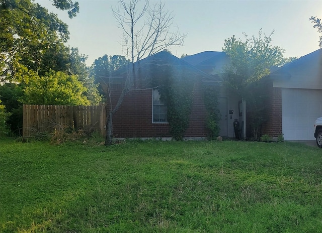 view of side of home with a yard and a garage