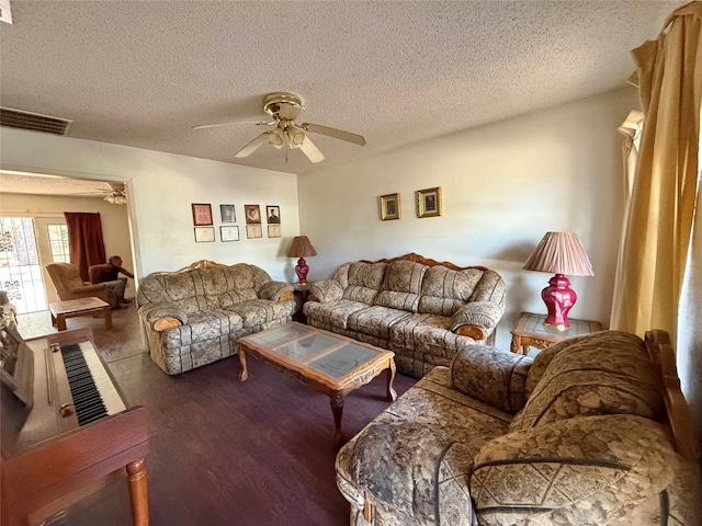 living room featuring ceiling fan, a textured ceiling, and hardwood / wood-style flooring