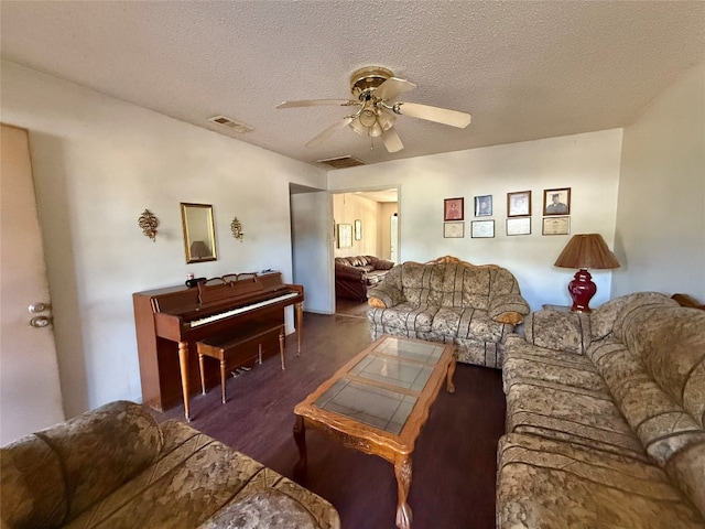 living room with ceiling fan, dark hardwood / wood-style floors, and a textured ceiling