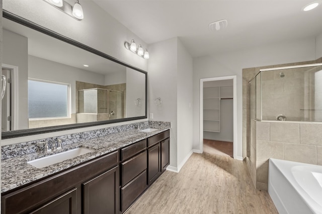 bathroom featuring hardwood / wood-style flooring, vanity, and plus walk in shower