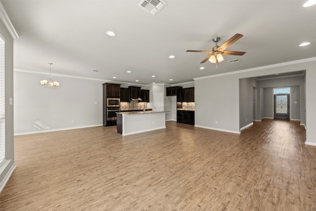 unfurnished living room featuring ceiling fan with notable chandelier, wood-type flooring, and crown molding