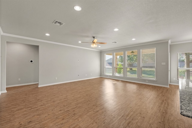 empty room with a wealth of natural light, ceiling fan, wood-type flooring, and ornamental molding