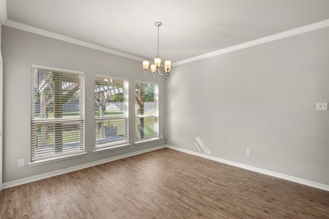 spare room with a notable chandelier, wood-type flooring, and ornamental molding