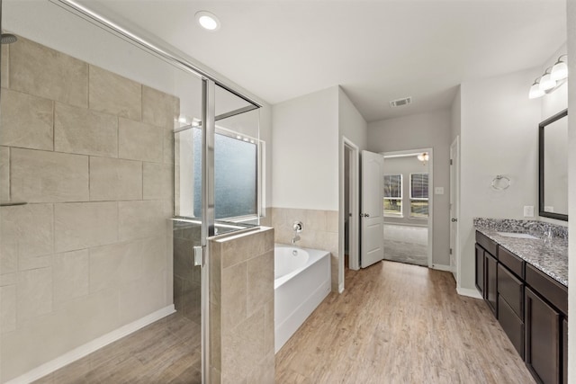 bathroom featuring hardwood / wood-style floors, vanity, and separate shower and tub