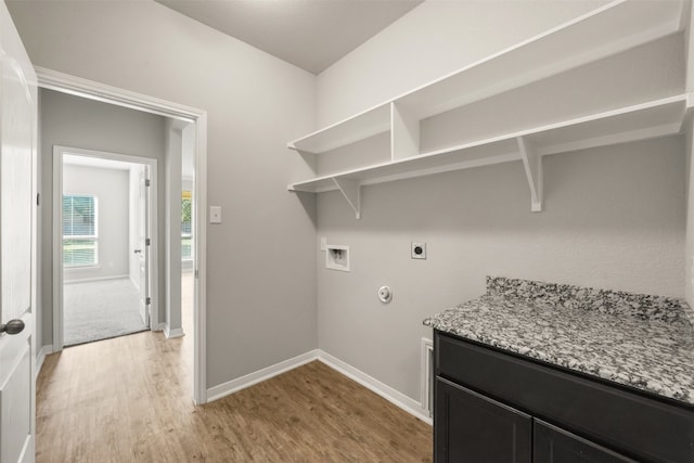 clothes washing area with electric dryer hookup, hookup for a gas dryer, light hardwood / wood-style floors, and washer hookup