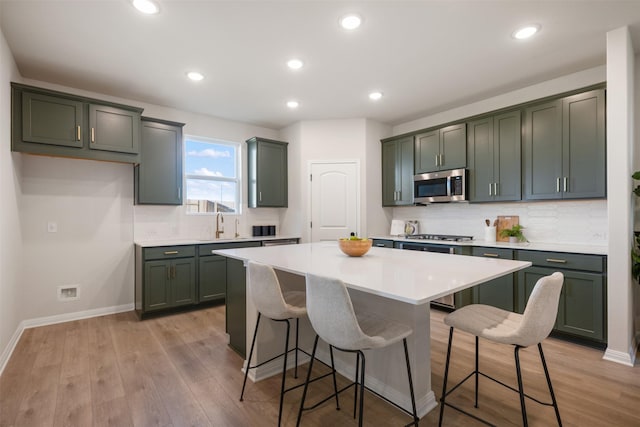 kitchen with a kitchen island, light hardwood / wood-style flooring, a breakfast bar area, and sink