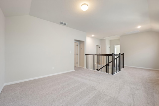 carpeted spare room featuring lofted ceiling