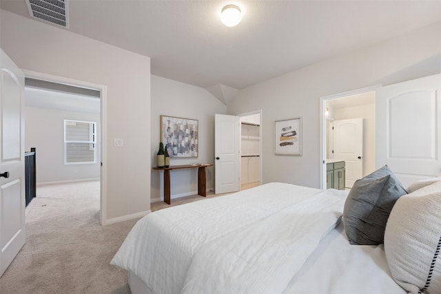 bedroom featuring light carpet and ensuite bath