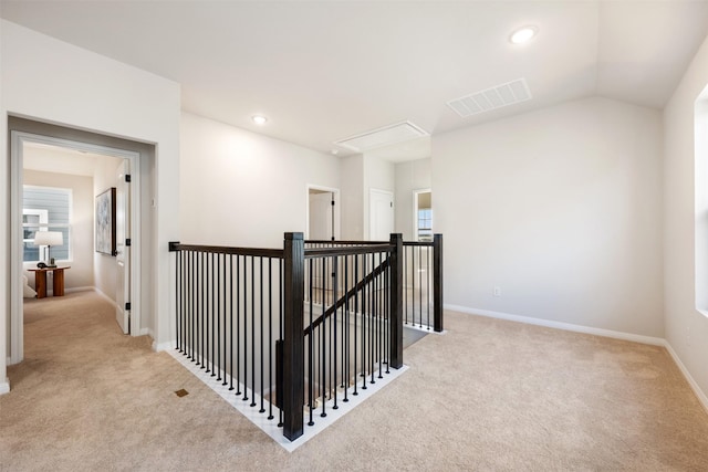 corridor featuring light colored carpet and vaulted ceiling