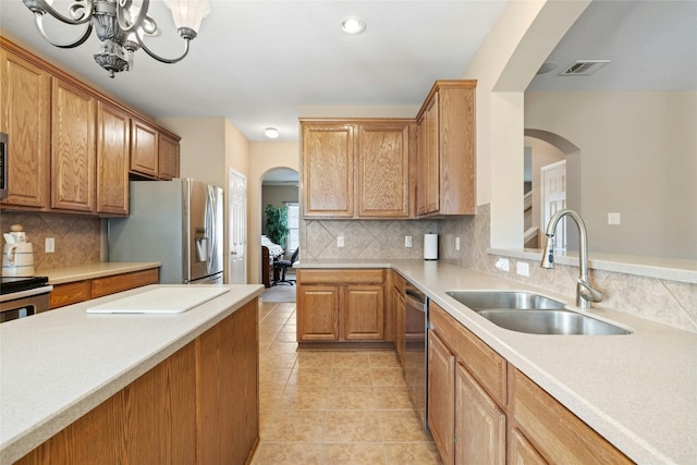 2603 White Stallion Way, Leander, TX 78641 - kitchen with stainless steel appliances, arched walkways, tasteful backsplash, light countertops, and recessed lighting