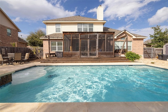 view of swimming pool featuring a sunroom