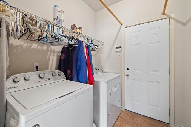 clothes washing area with light tile patterned flooring and washing machine and clothes dryer