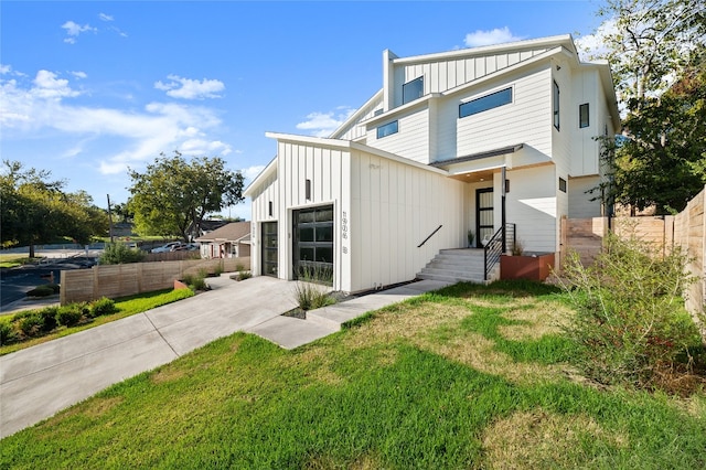 rear view of property featuring a garage and a yard