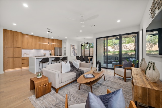 living room with ceiling fan and light hardwood / wood-style flooring