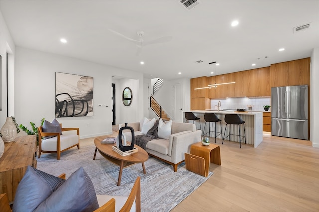 living room featuring light hardwood / wood-style floors and ceiling fan