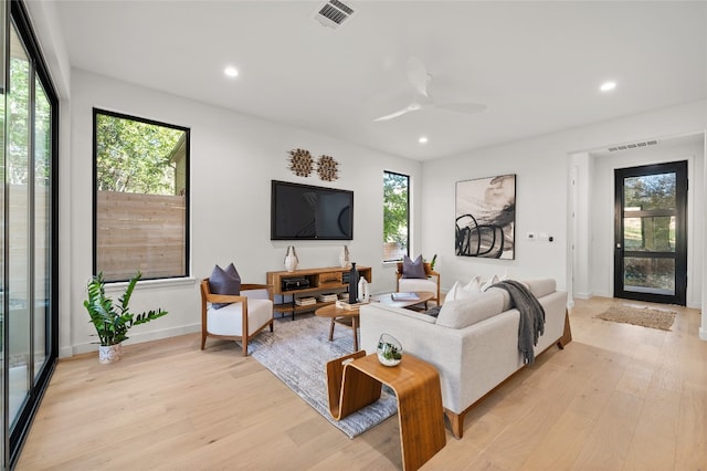 living room featuring ceiling fan, a healthy amount of sunlight, and light wood-type flooring