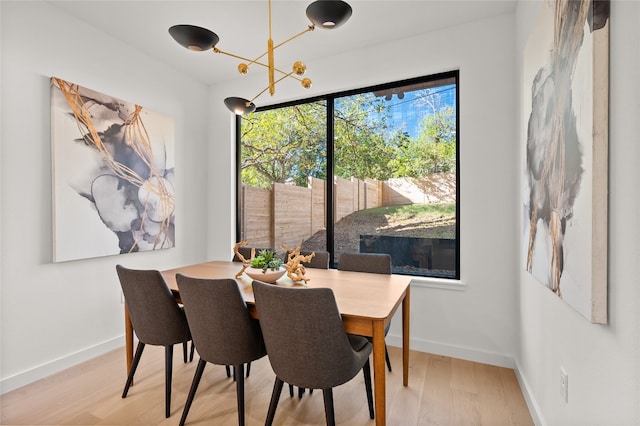 dining space with a chandelier and light hardwood / wood-style flooring