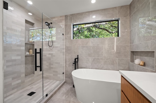 bathroom with vanity, tile walls, and plus walk in shower