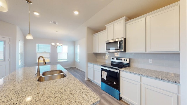 kitchen featuring pendant lighting, sink, light hardwood / wood-style flooring, white cabinetry, and stainless steel appliances