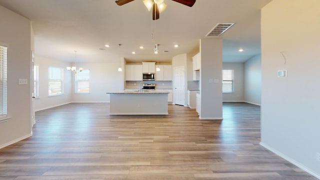 kitchen featuring a healthy amount of sunlight, light hardwood / wood-style floors, a kitchen island with sink, and stainless steel appliances