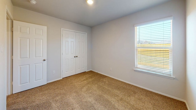 unfurnished bedroom with carpet and a closet