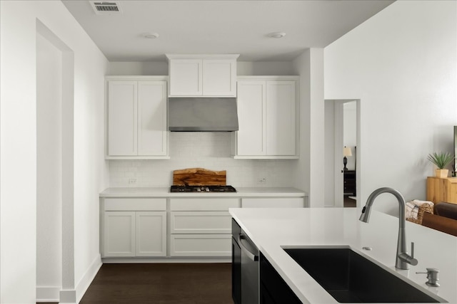 kitchen featuring white cabinets, sink, dark hardwood / wood-style floors, range hood, and stainless steel appliances