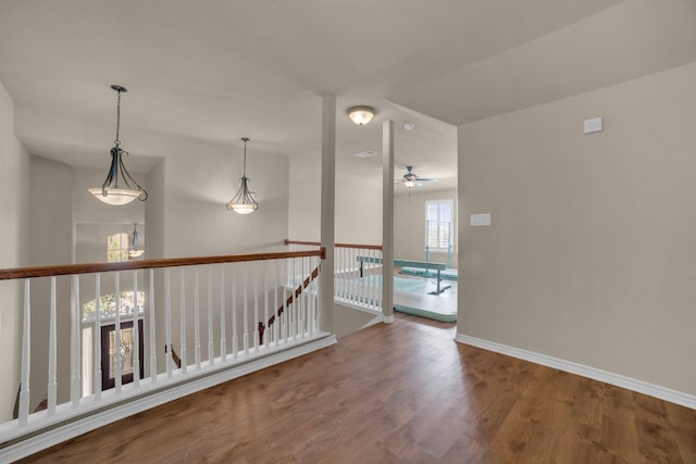 spare room with a wealth of natural light, hardwood / wood-style floors, and ceiling fan