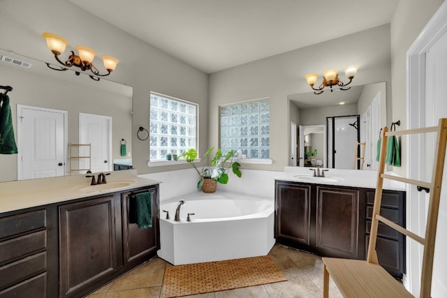 bathroom with vanity, an inviting chandelier, tile patterned floors, and a bathing tub