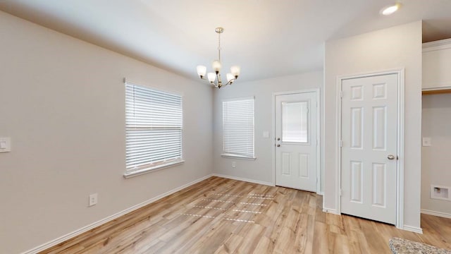 interior space featuring light wood-type flooring and a notable chandelier