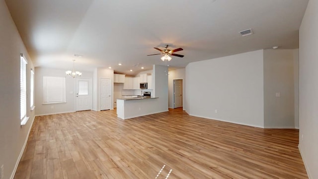 unfurnished living room featuring light hardwood / wood-style floors and ceiling fan with notable chandelier