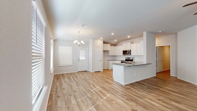 kitchen with plenty of natural light, white cabinetry, appliances with stainless steel finishes, and light hardwood / wood-style flooring