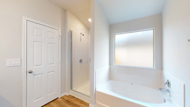 bathroom with wood-type flooring and shower with separate bathtub