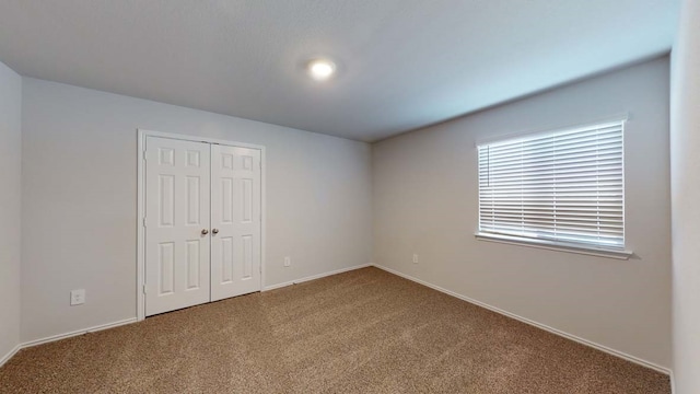 unfurnished bedroom with carpet floors and a closet