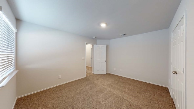 unfurnished bedroom featuring light carpet