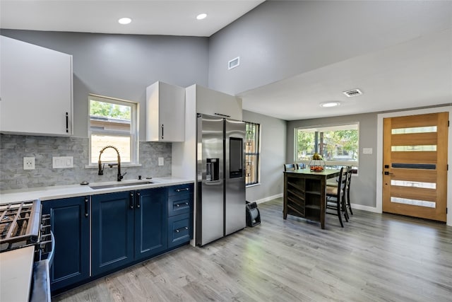 kitchen with blue cabinetry, sink, stainless steel appliances, and plenty of natural light