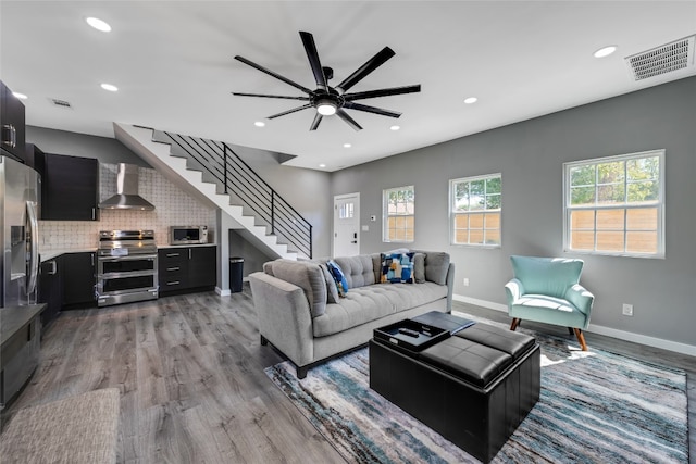 living room with light wood-type flooring and ceiling fan