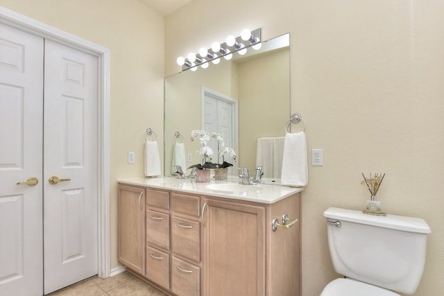 bathroom with tile patterned flooring, vanity, and toilet