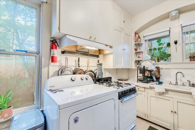 kitchen with white cabinetry, plenty of natural light, and washer / dryer