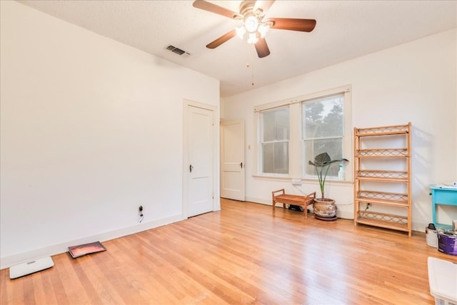 interior space featuring a textured ceiling, light wood-type flooring, and ceiling fan