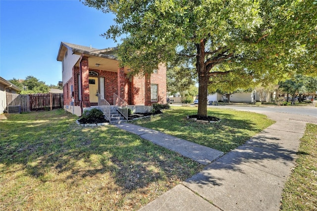 view of front of house with central AC unit and a front yard