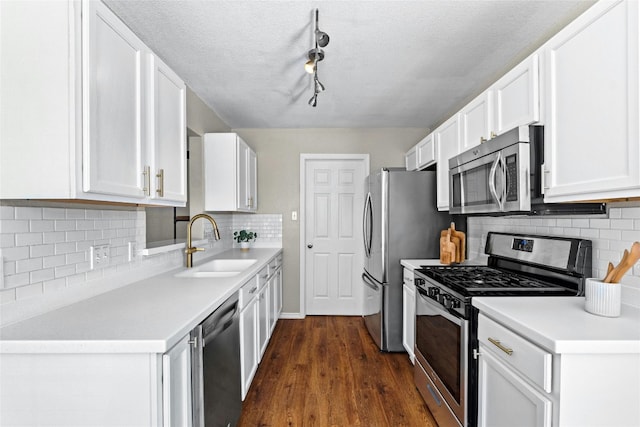 kitchen featuring white cabinetry, sink, dark wood-type flooring, and appliances with stainless steel finishes