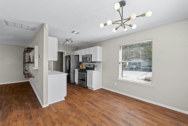 kitchen featuring appliances with stainless steel finishes, dark hardwood / wood-style floors, white cabinetry, and decorative light fixtures